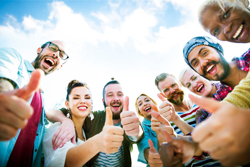 Group of Smiling People Giving a Thumbs Up